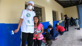 プエルト・グァラニ村の公立学校の生徒たちとともにペンキ塗り